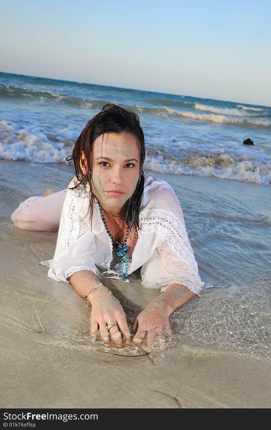 Portrait of young fashion woman lying on the sand of tropical beach. Portrait of young fashion woman lying on the sand of tropical beach