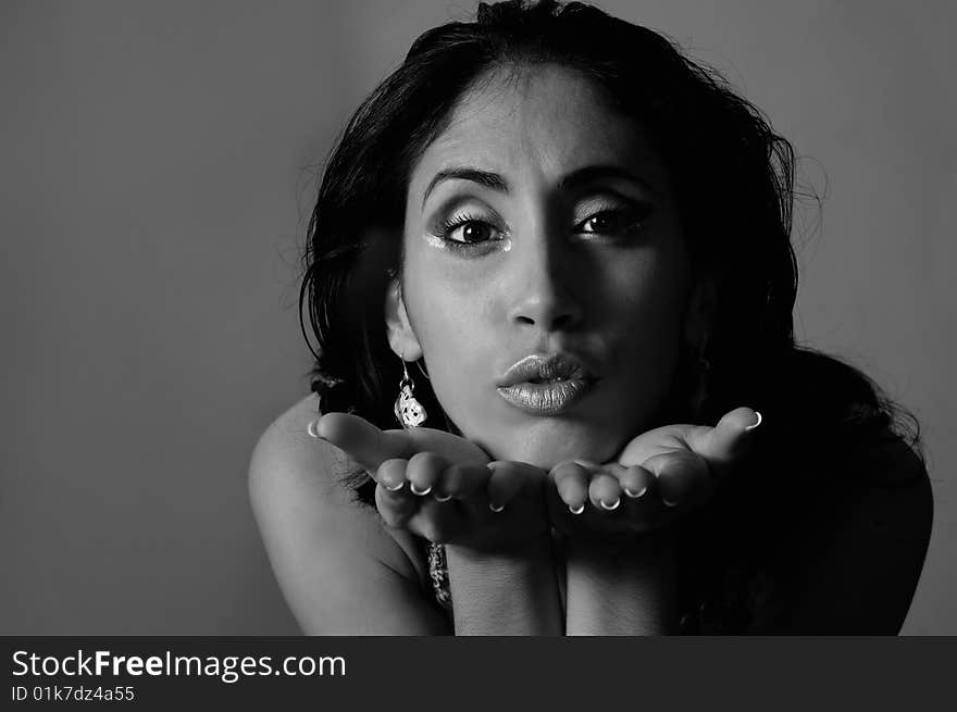 B&W portrait of young woman blowing a kiss