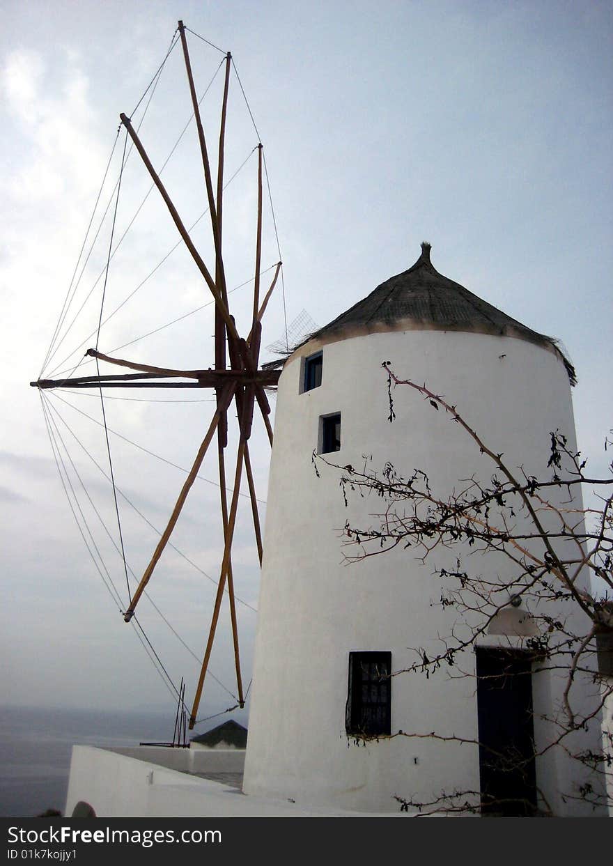 A white-washed windmill looking towards the sea on the greek island of Santorini. A white-washed windmill looking towards the sea on the greek island of Santorini