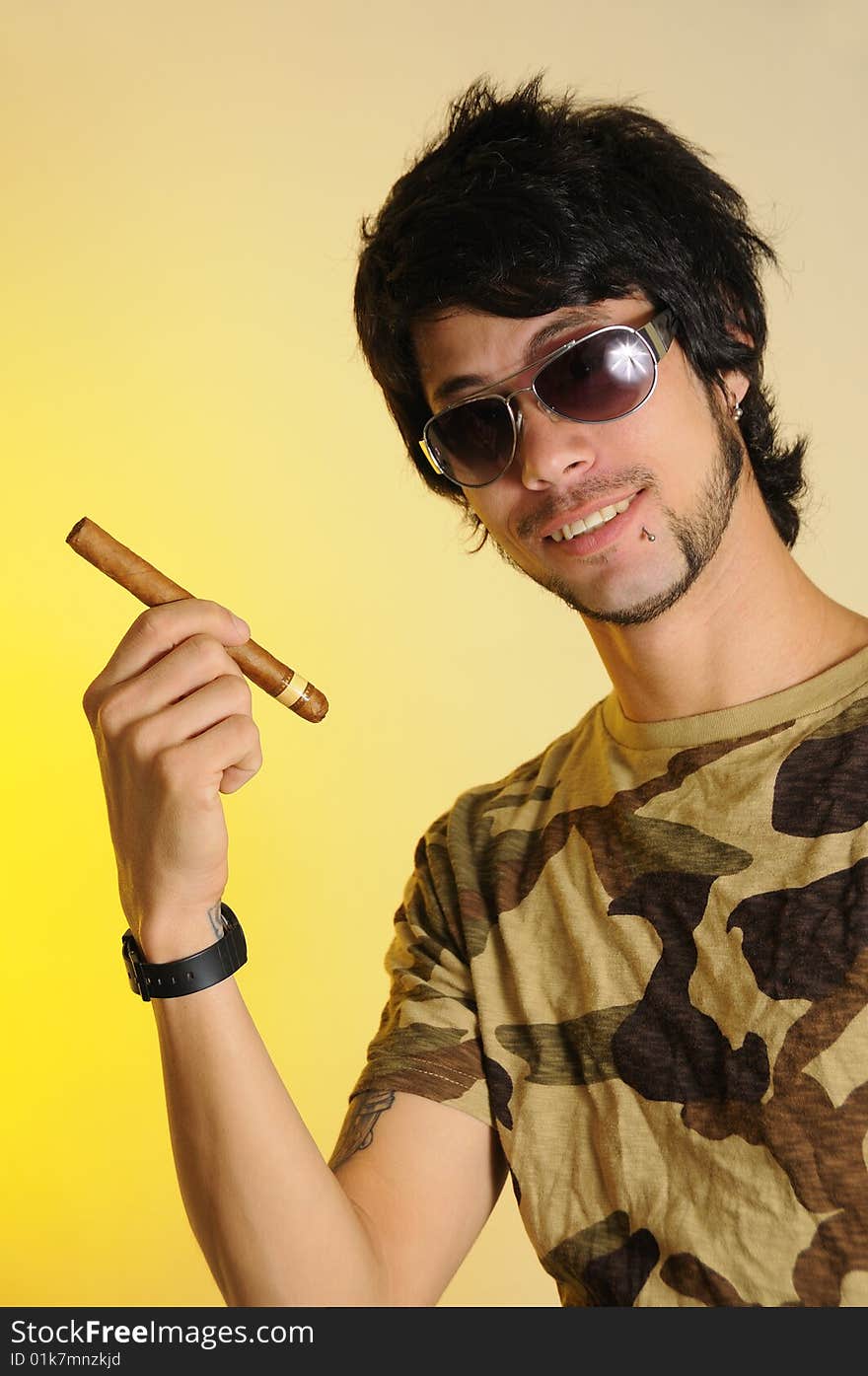 Portrait of trendy latino man holding cigar over yellow background. Portrait of trendy latino man holding cigar over yellow background