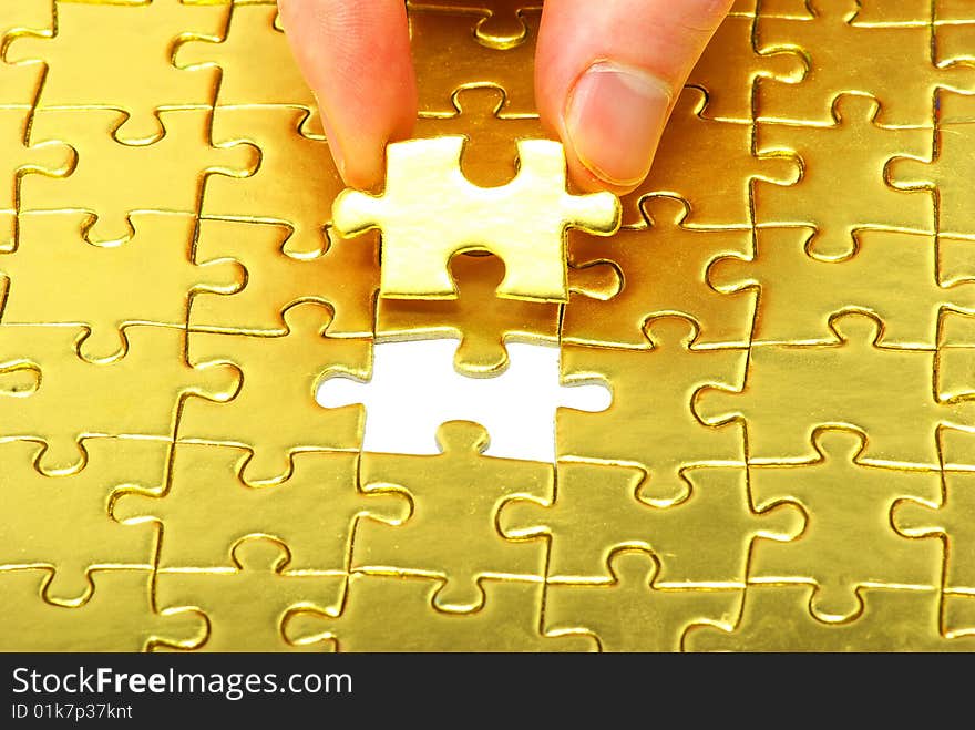 Woman fingers holdings gold puzzle