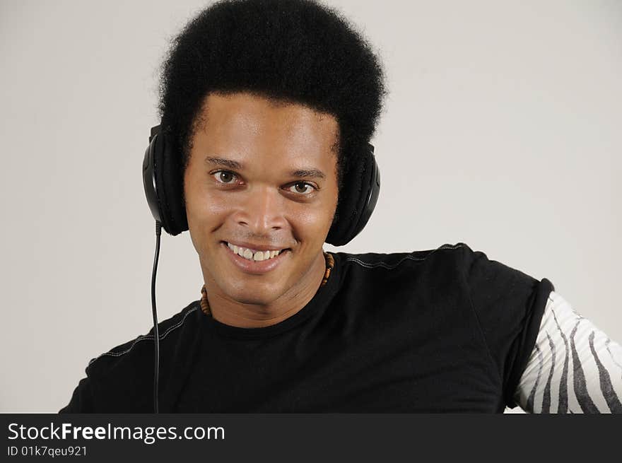 Portrait of young trendy african holding headphones with happy expression. Portrait of young trendy african holding headphones with happy expression