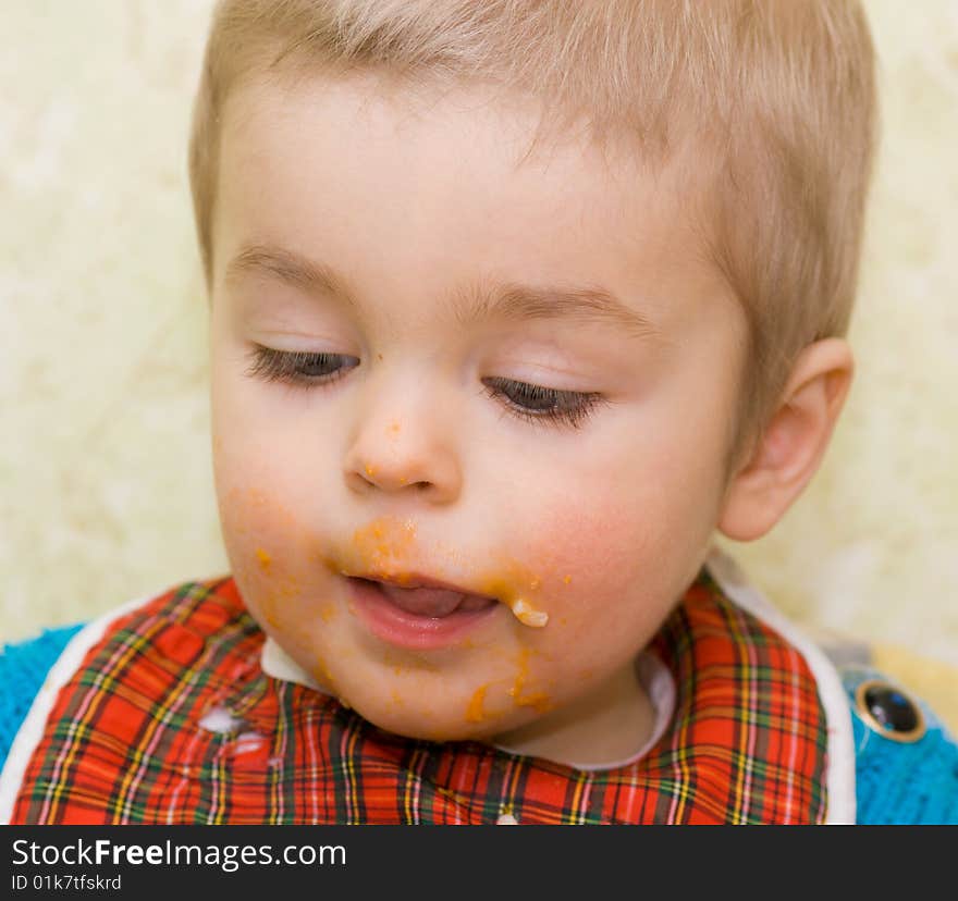 Close-up shot of cute little boy stained with squash