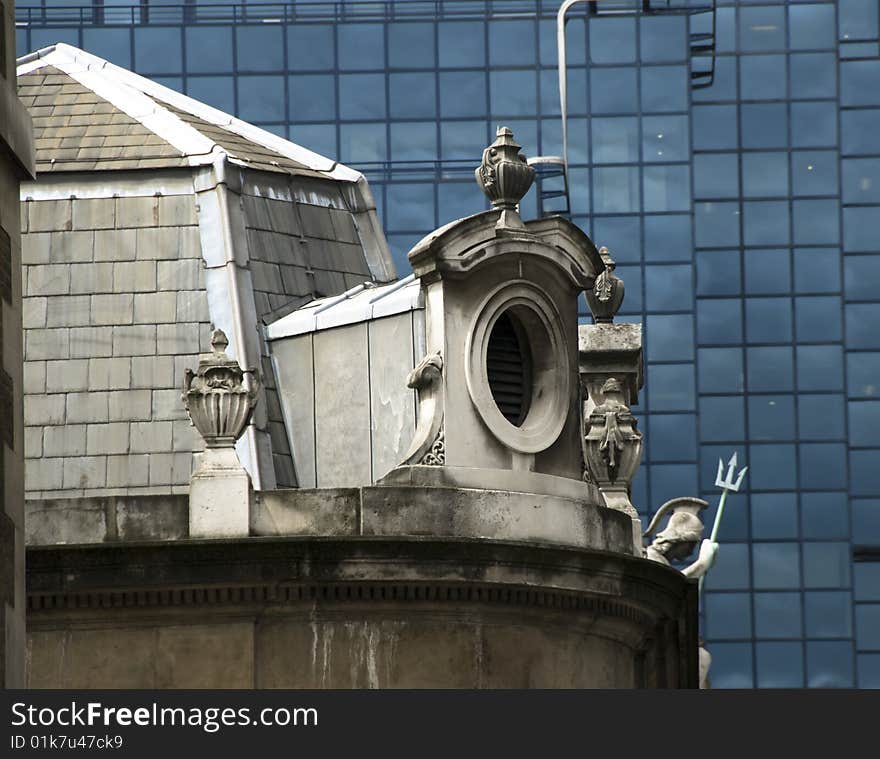 Window of an old building, classical architecture, in contrast with modern glass wall. London. Window of an old building, classical architecture, in contrast with modern glass wall. London.