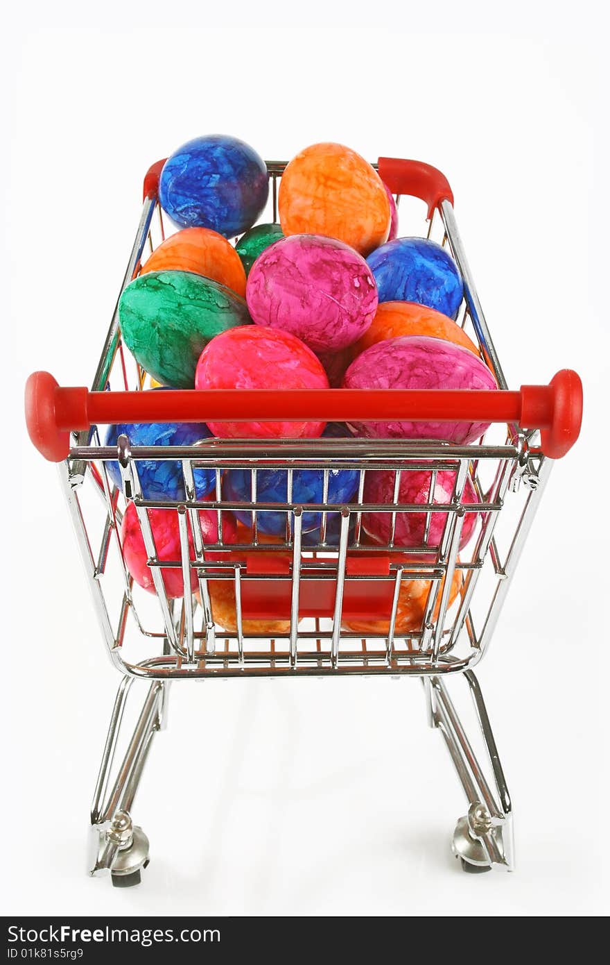 Colorful easter eggs in a shopping trolley on white background