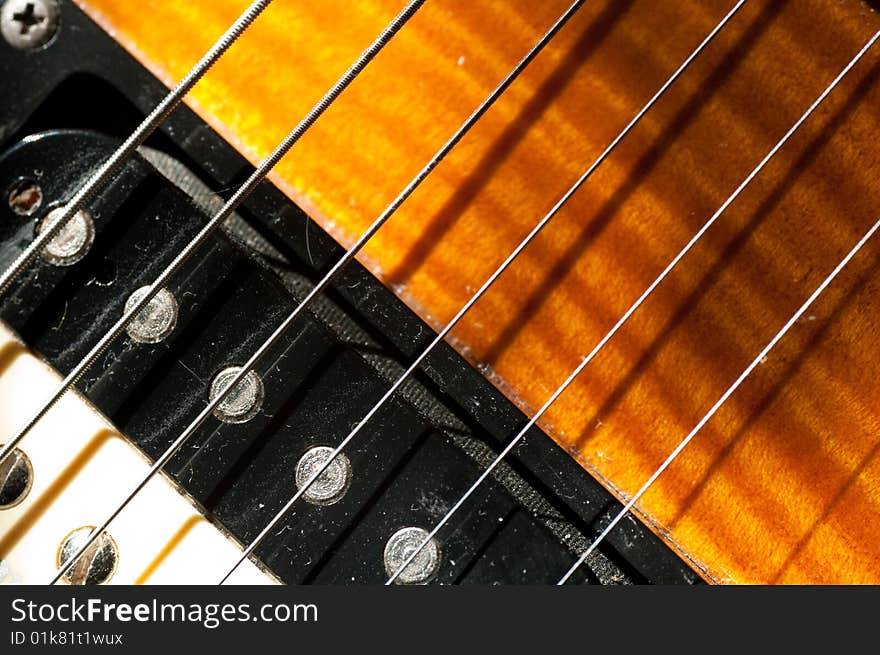 Macro shot of guitar strings, pickups and sunburst finish