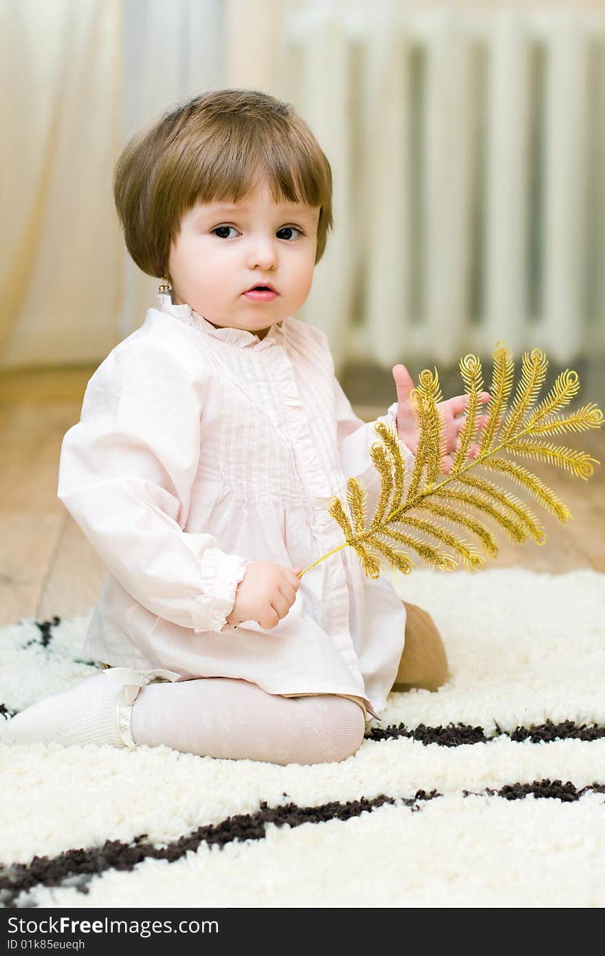 Girl plays with a branch on the floor. Girl plays with a branch on the floor