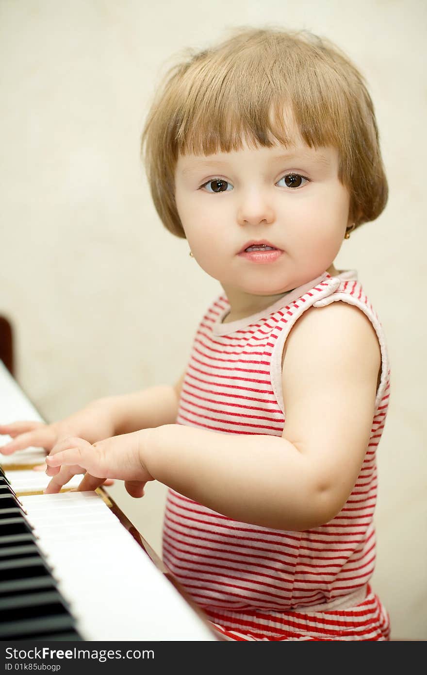 Beautiful little girl plays piano