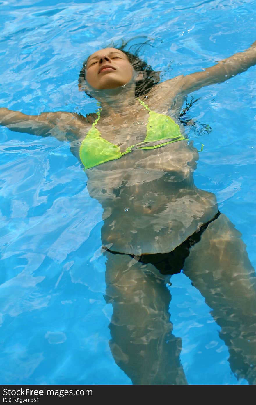 Woman takes a sunbath in the swimming pool. Woman takes a sunbath in the swimming pool