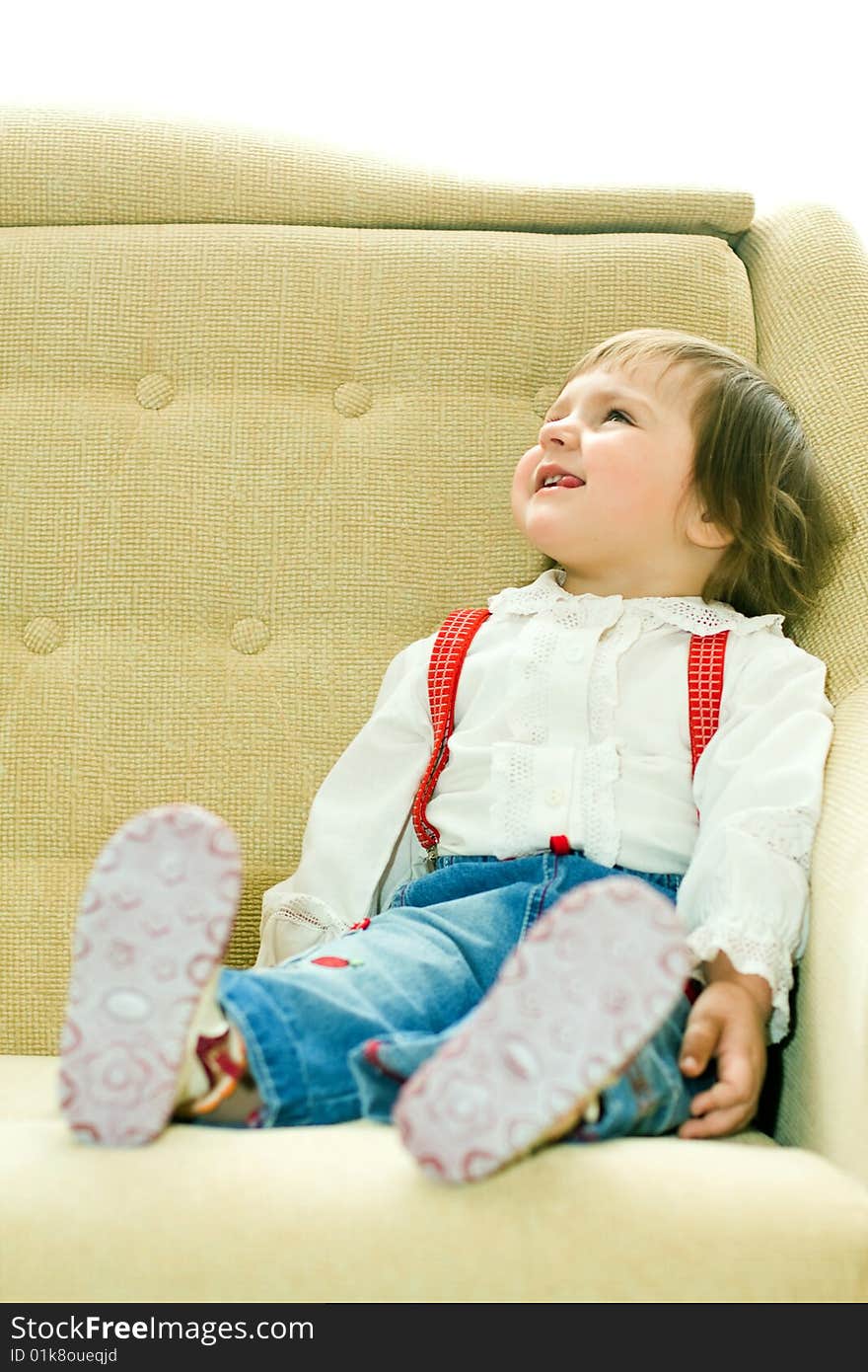 Funny girl sits on sofa and looks up. Funny girl sits on sofa and looks up