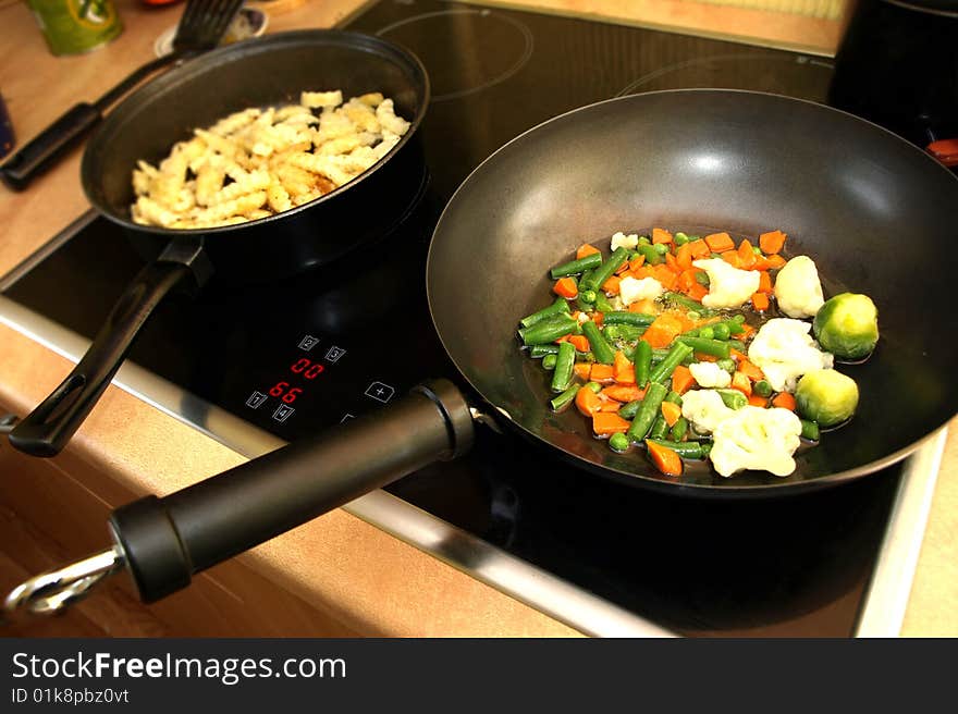 Preparing the meal - stir fry vegetables and potatoes in wok pan. Preparing the meal - stir fry vegetables and potatoes in wok pan