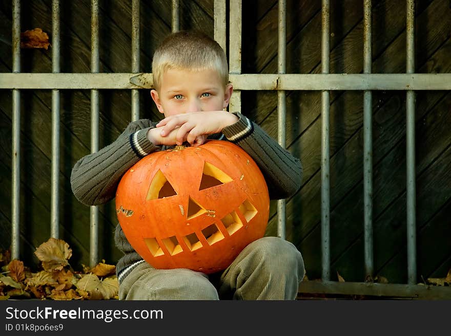 Sitting little boy with halloween pumpkin. Sitting little boy with halloween pumpkin