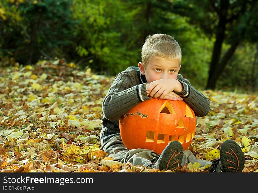 Sitting little boy with halloween pumpkin. Sitting little boy with halloween pumpkin