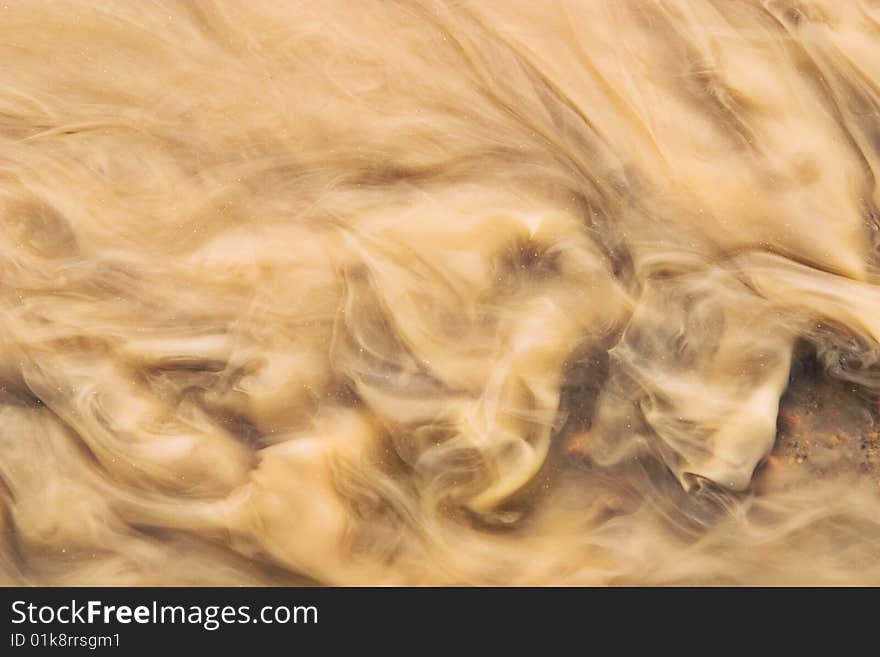 Stream of the dissolved clay, coffee with milk colour. Stream of the dissolved clay, coffee with milk colour