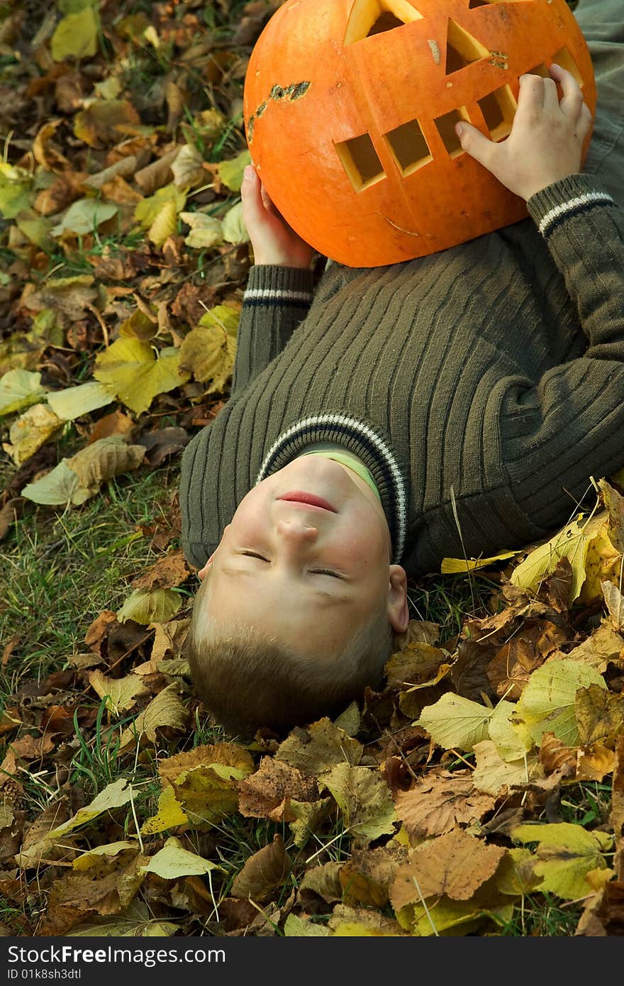 Laying little boy with halloween pumpkin. Laying little boy with halloween pumpkin