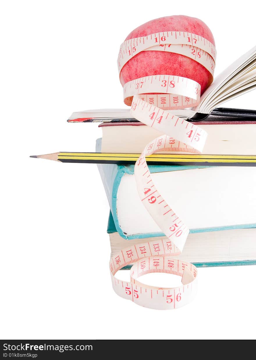 Big ripe red apple with white measure tape around it on pile of books as metaphore of healthy eating and diet. Big ripe red apple with white measure tape around it on pile of books as metaphore of healthy eating and diet