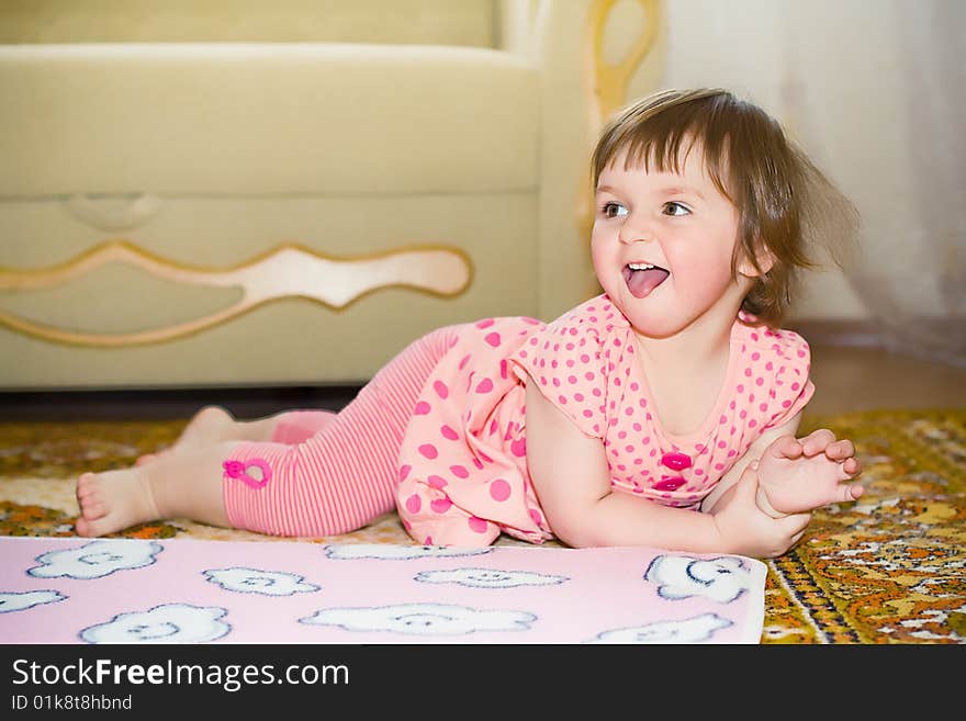 Little girl lies on the floor and laughs. Little girl lies on the floor and laughs