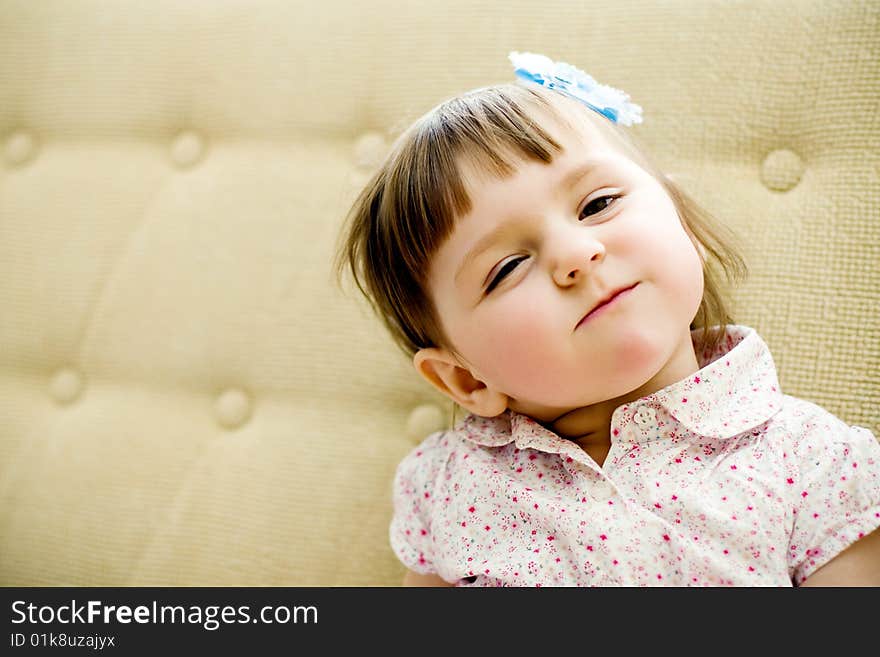 Funny girl sits on sofa