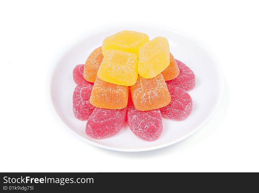 Multicoloured gumdrops on white saucer, isolated on white. Multicoloured gumdrops on white saucer, isolated on white