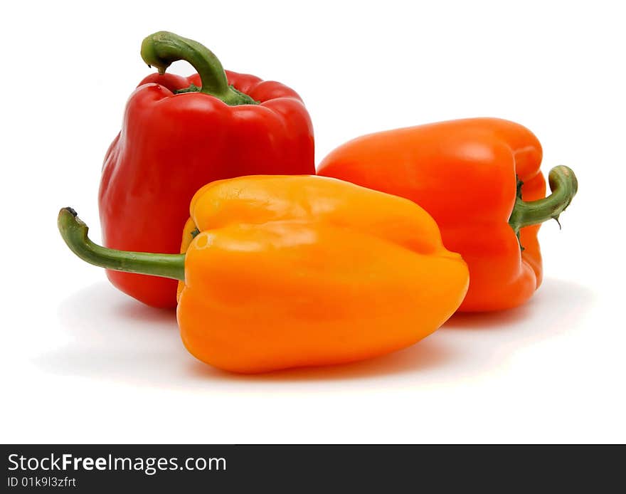 Three sweet bell peppers in red, orange and yellow colors on white background. Three sweet bell peppers in red, orange and yellow colors on white background