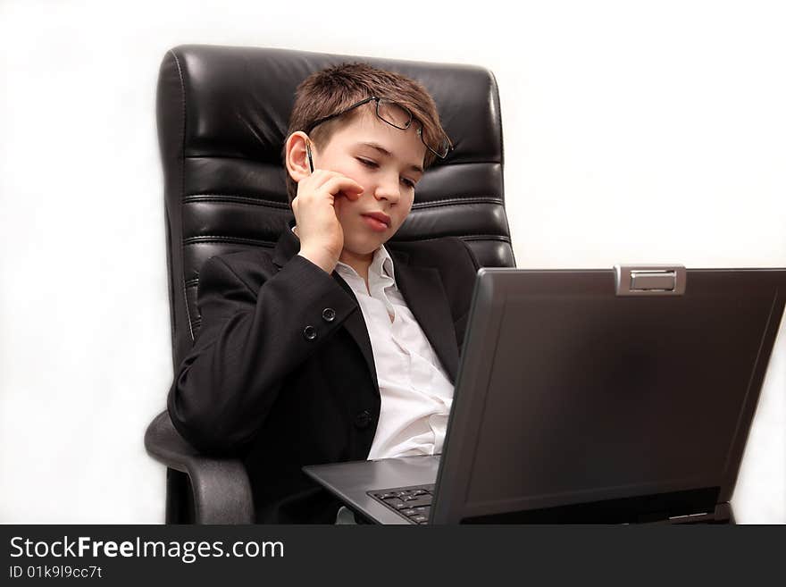 A boy sitting in large  chair  with a notebook. A boy sitting in large  chair  with a notebook