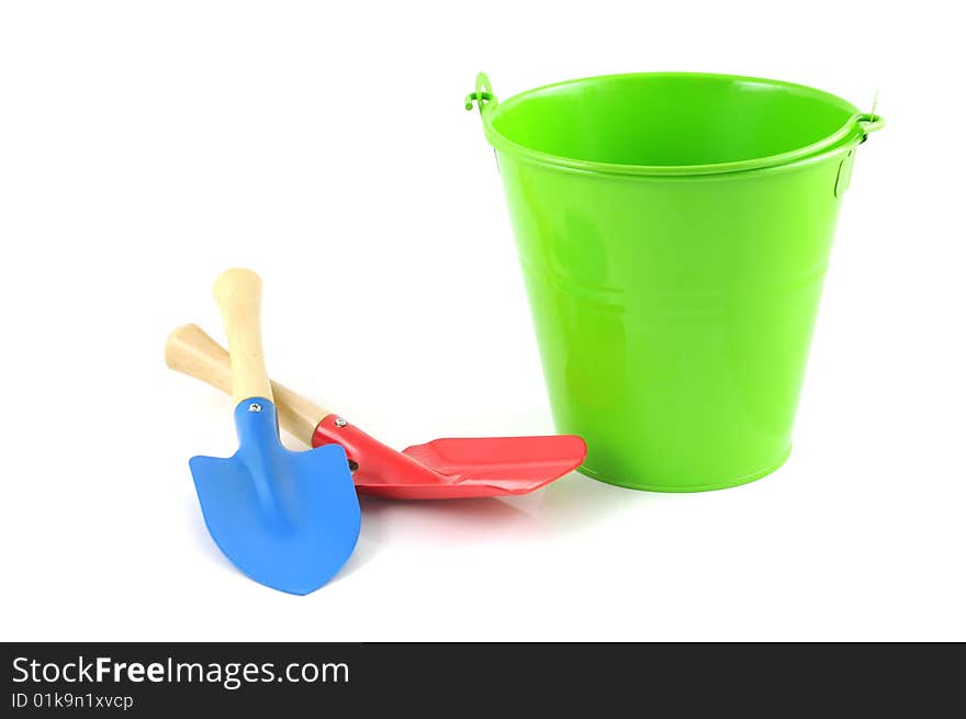 Green bucket with garden tools isolated on white background