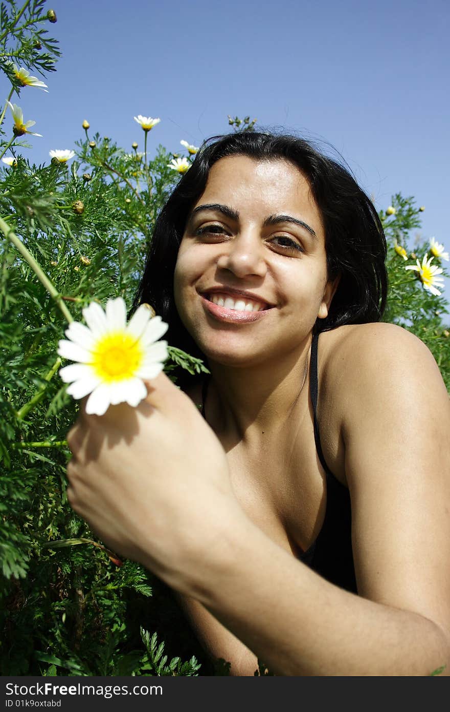 Woman smiling holding a flower. Woman smiling holding a flower