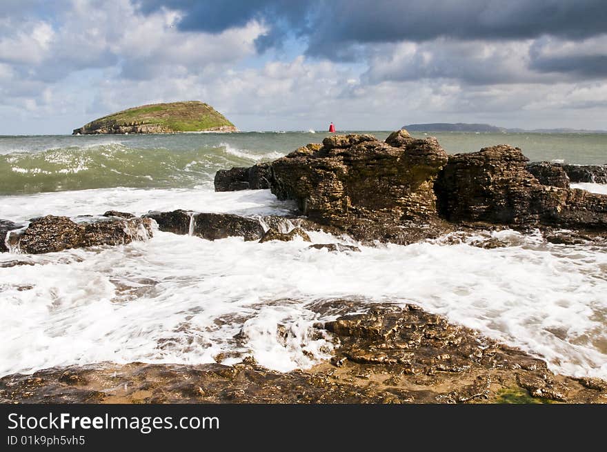 Puffin Island from the Isle of Anglesey with wave coming in over rocks