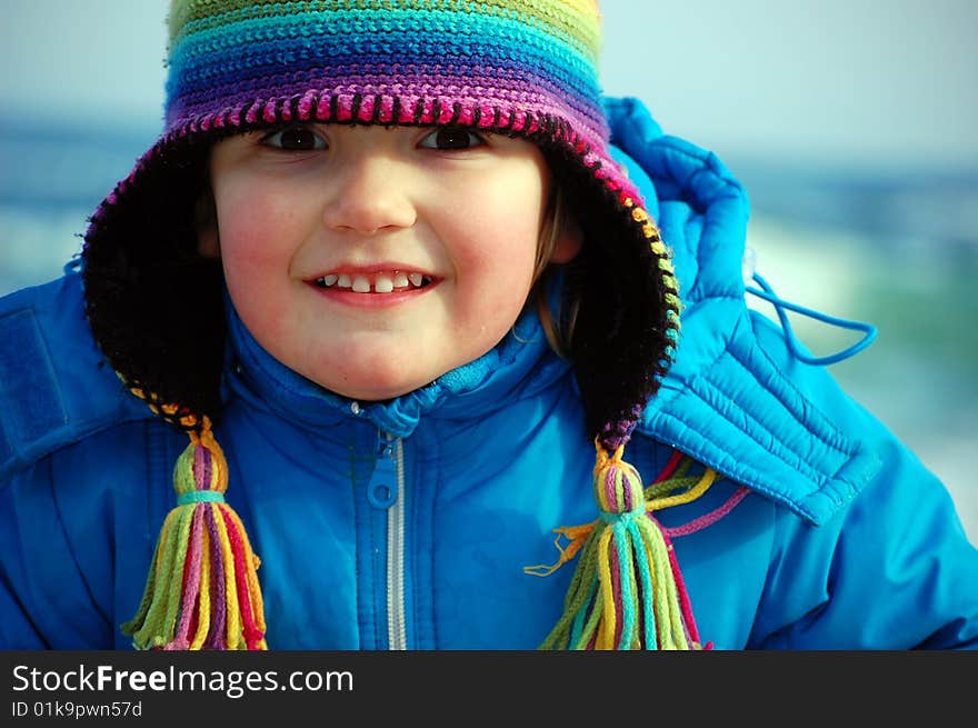 A pretty girl with a rainbow hat smiles with all her senses. A pretty girl with a rainbow hat smiles with all her senses.