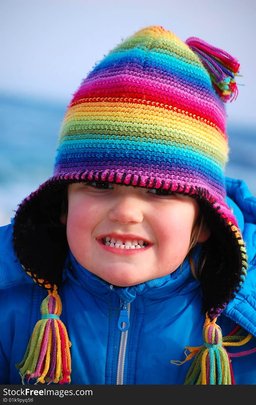 A pretty girl with a rainbow hat smiles with all her senses. A pretty girl with a rainbow hat smiles with all her senses.