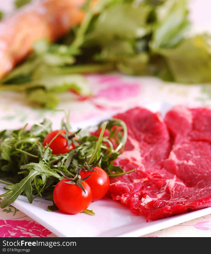 Raw meat with tomatoes and rucola