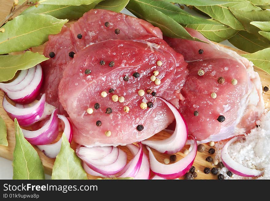 Raw pork meat with spice on wooden board