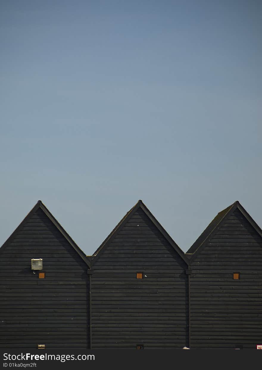 3 wooden fishermen's huts shot against a blue sky.  Typical of many British fishing villages. 3 wooden fishermen's huts shot against a blue sky.  Typical of many British fishing villages