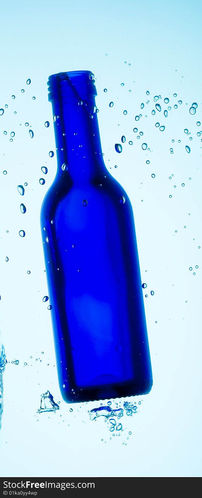 Bottle and creative splashing water.

Isolated on white