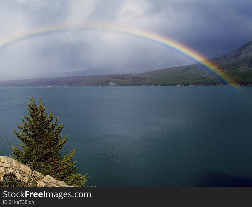 Rainbow over a lake with dark clouds