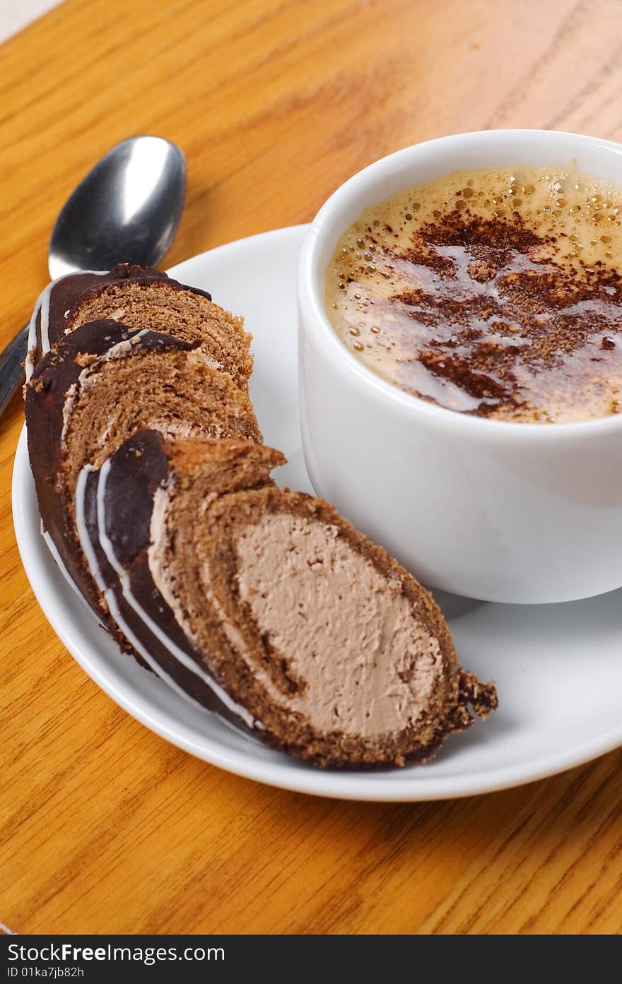 Cup of coffee with dessert on the wooden table