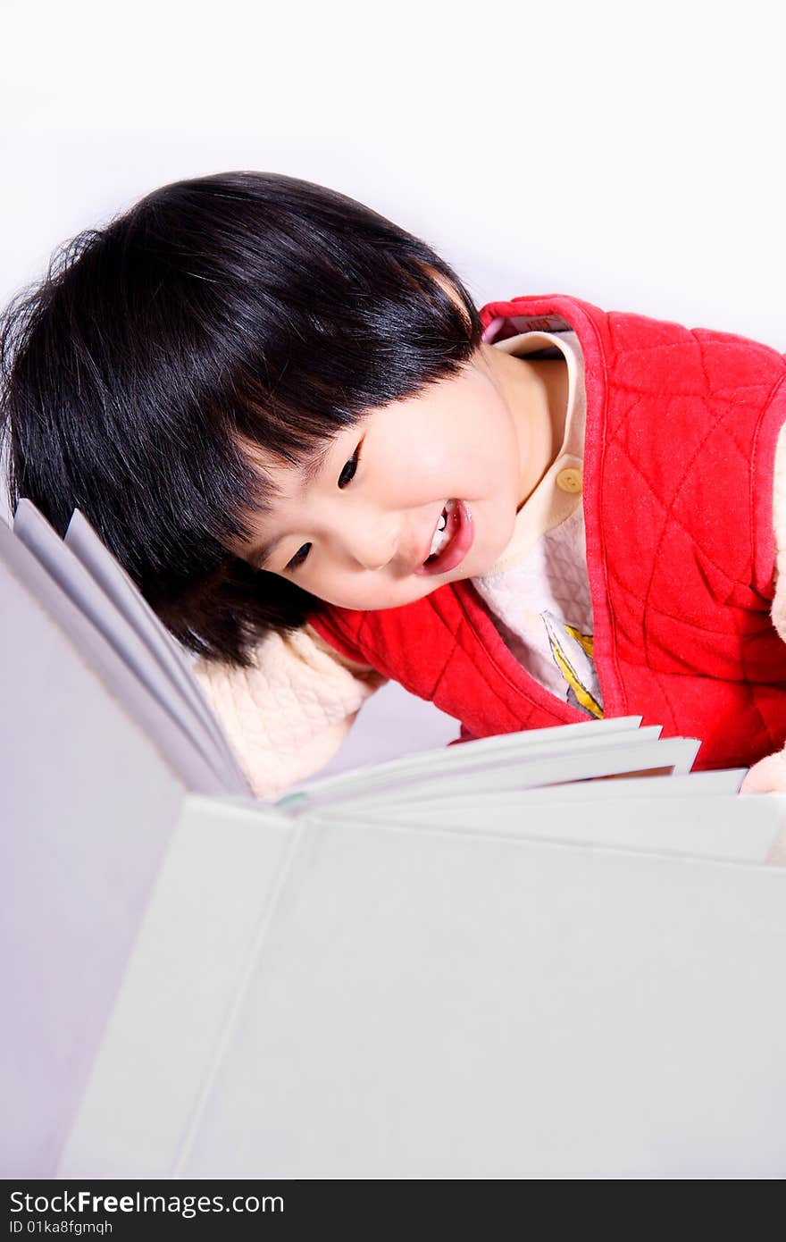 A picture of a little chinese girl reading book and laughing happily