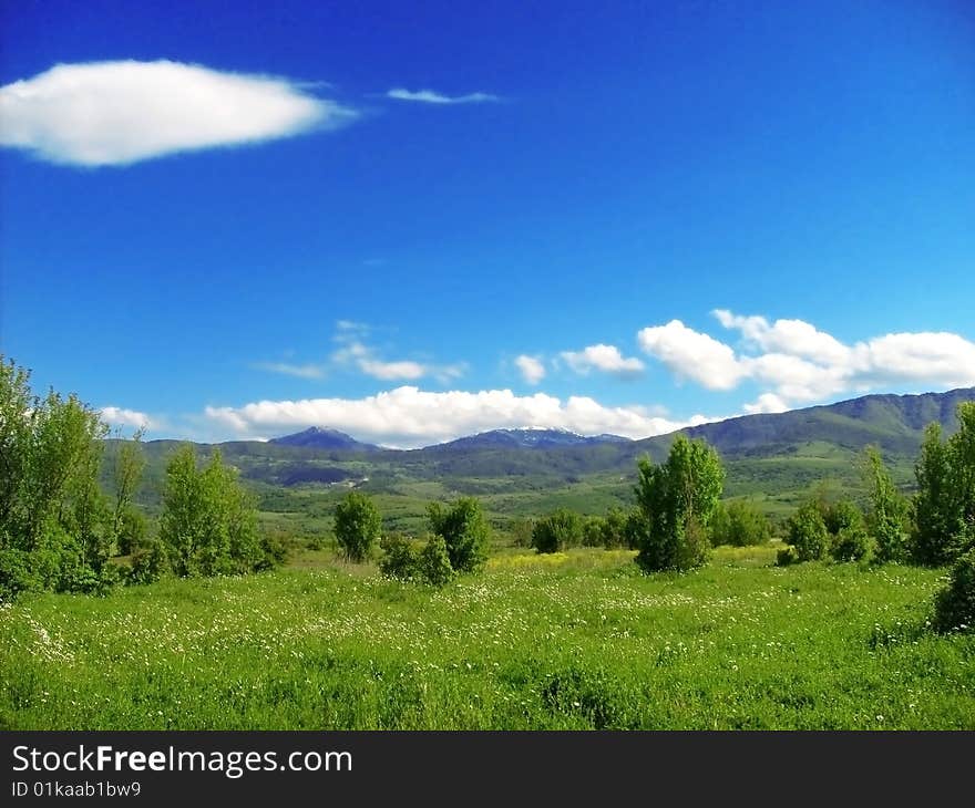 Green meadow with small mountains