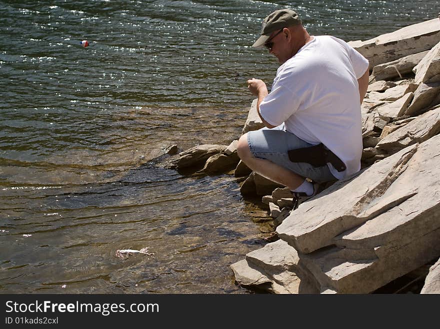 Man catching a brook trout in a lake in the Black Hills of South Dakota. Man catching a brook trout in a lake in the Black Hills of South Dakota