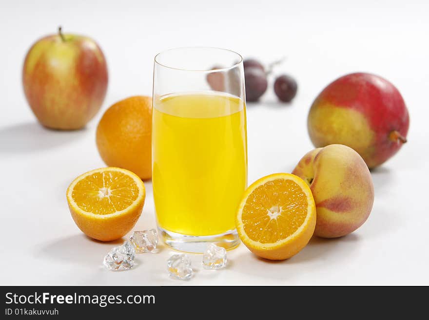 Juice glass with fruits and ice on white background