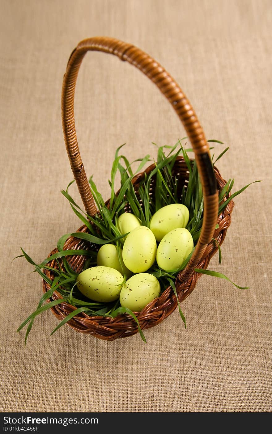 Basket with Easter eggs in grass, selective focus on eggs. Basket with Easter eggs in grass, selective focus on eggs