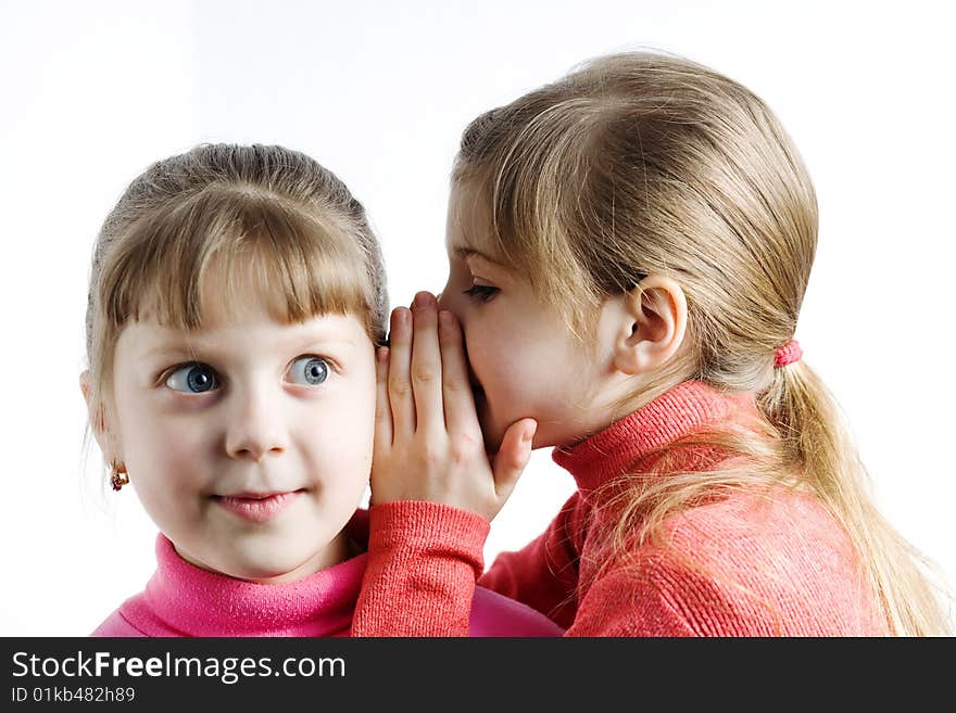 An image of a girl whispering something to surprised girl