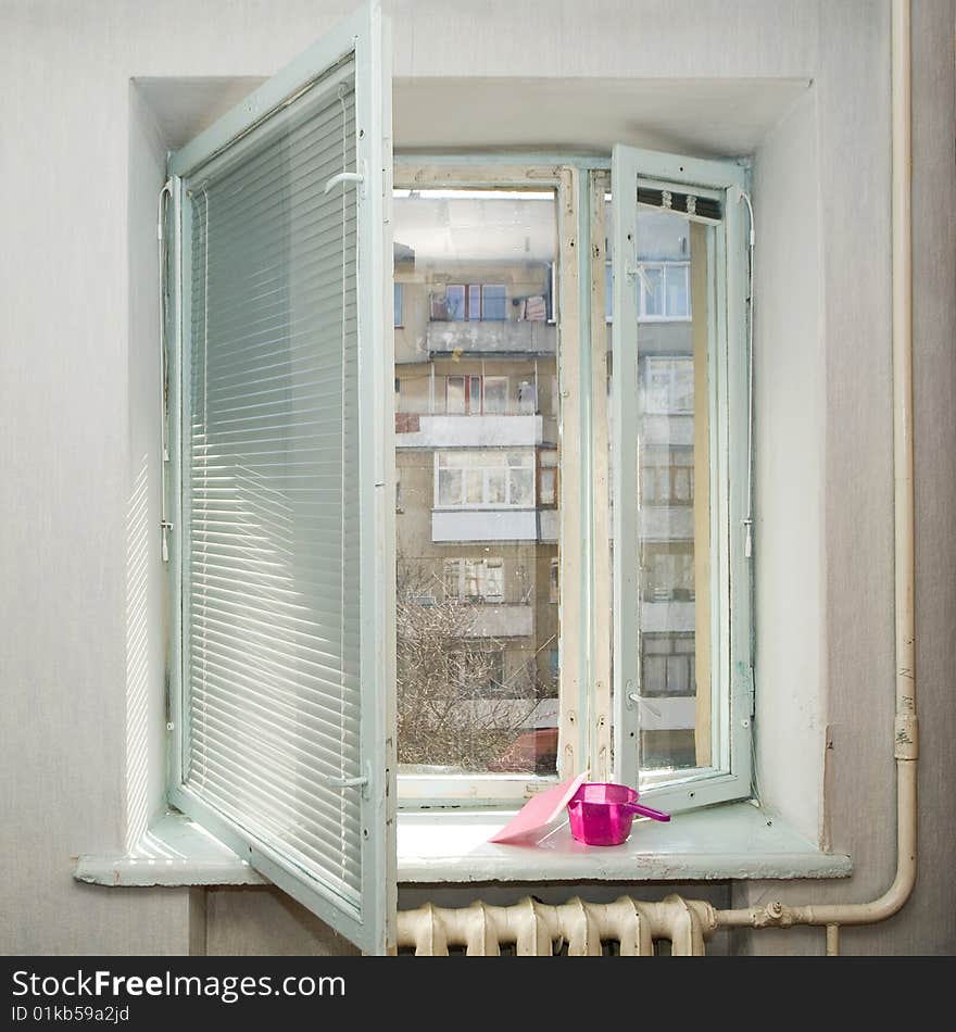 An image of an open window and jug with sponge on it