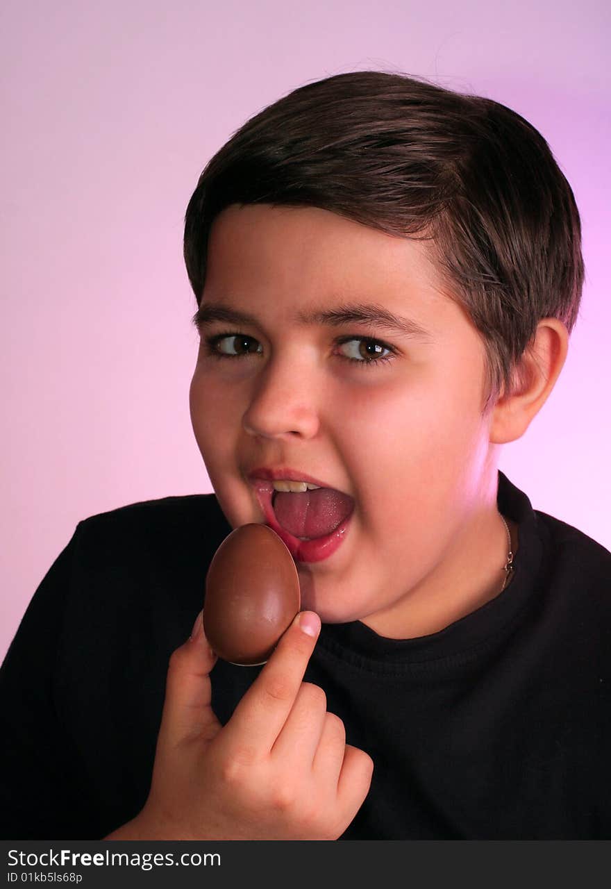 Little boy eats chocolate egg