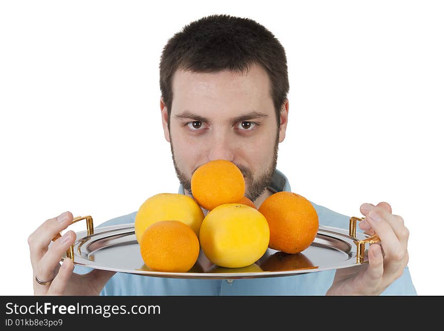 Young, handsome man, holding a plate with fruits in front of his face. Young, handsome man, holding a plate with fruits in front of his face