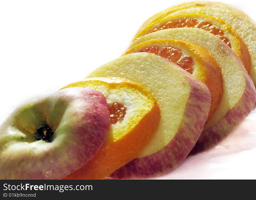 Fruit slicing of apples and oranges on a white background