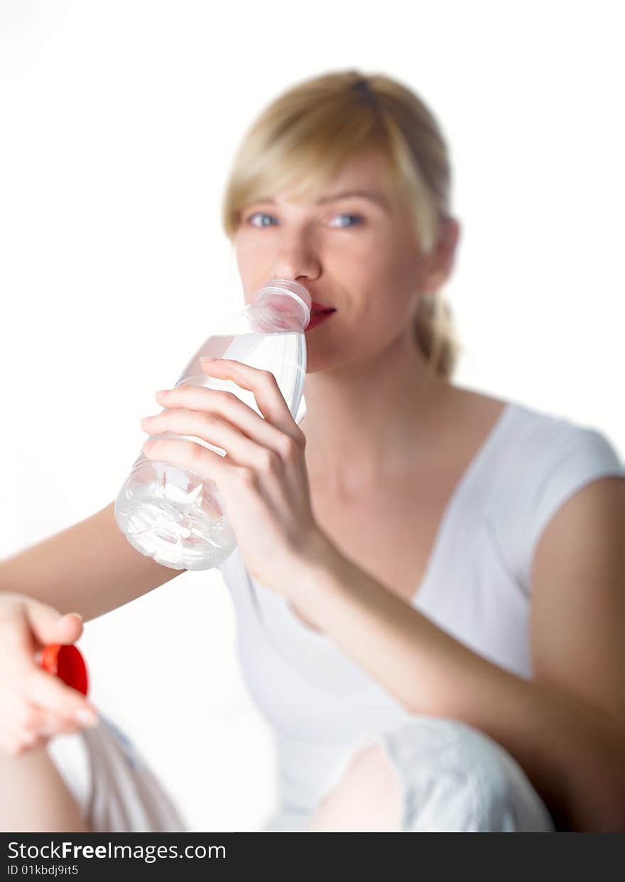 The girl of a sports kind with a bottle of water in a hand. The girl of a sports kind with a bottle of water in a hand