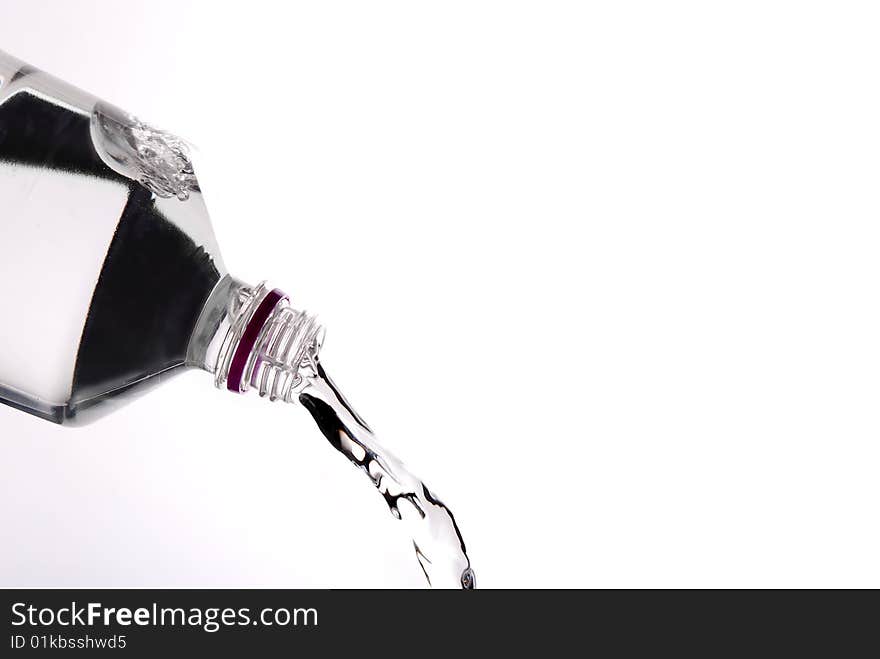 Pouring water from a bottle isolated on white background