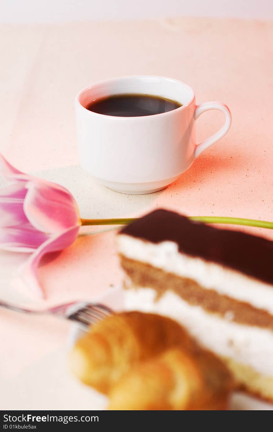 Pastry in the saucer and coffee on the tablecloth. Pastry in the saucer and coffee on the tablecloth