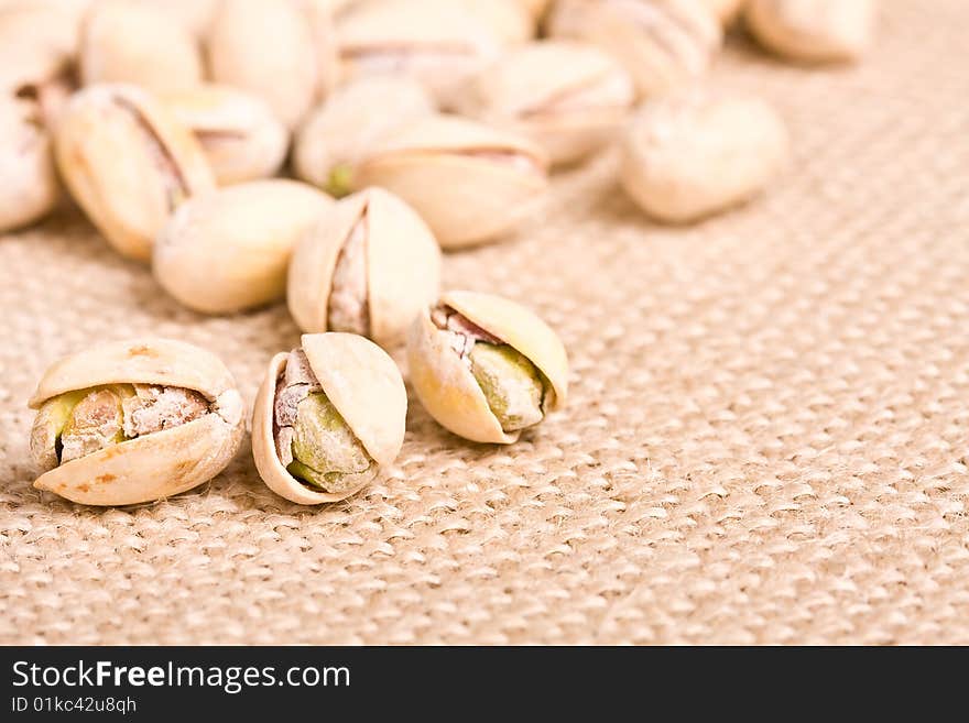 Healthy nuts pistachios on a burlap canvas shallow depth of view. Healthy nuts pistachios on a burlap canvas shallow depth of view